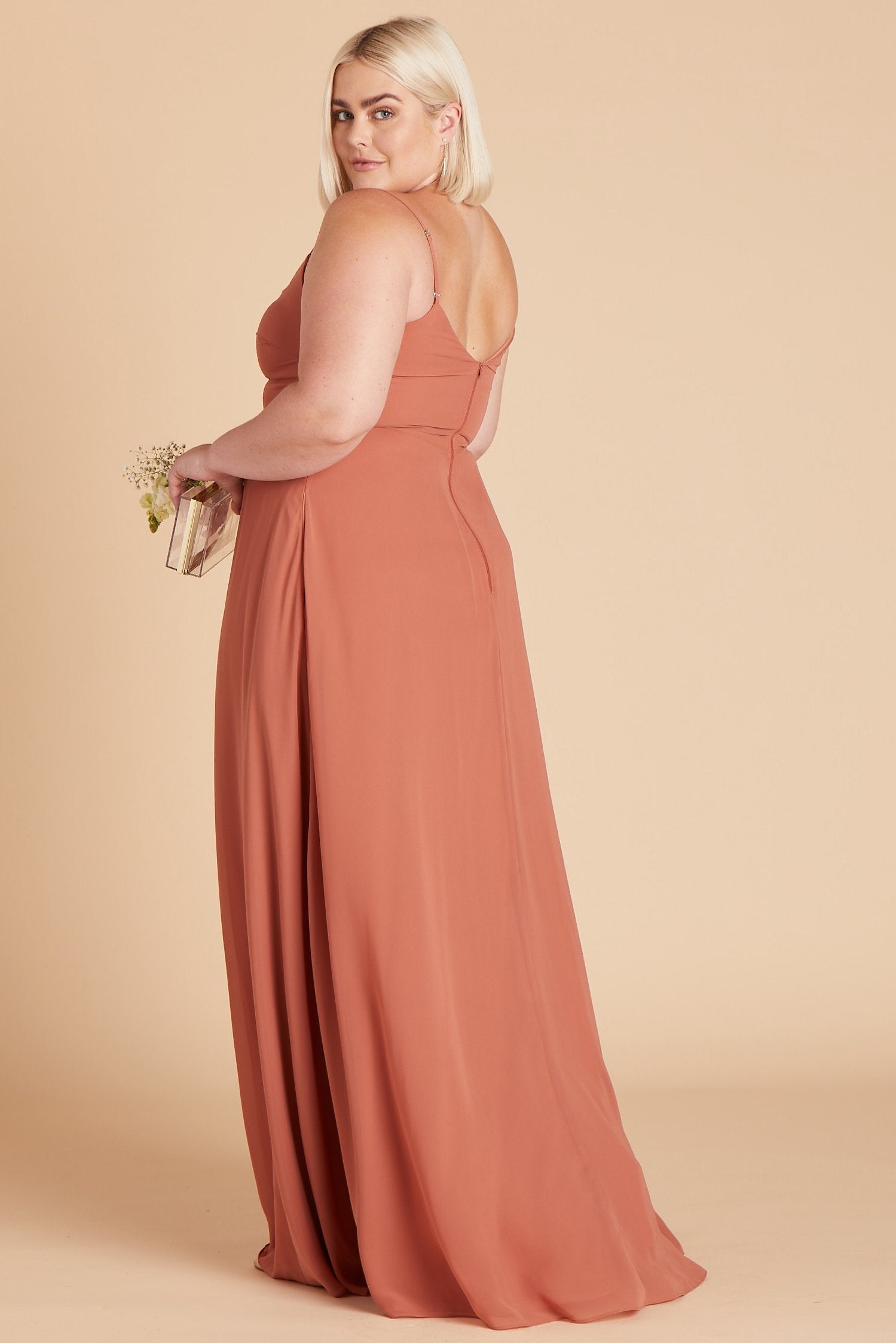 Side view of the floor-length Devin Convertible Plus Size Bridesmaid Dress features a fitted bust and waist with a flowing skirt that moves with the model.