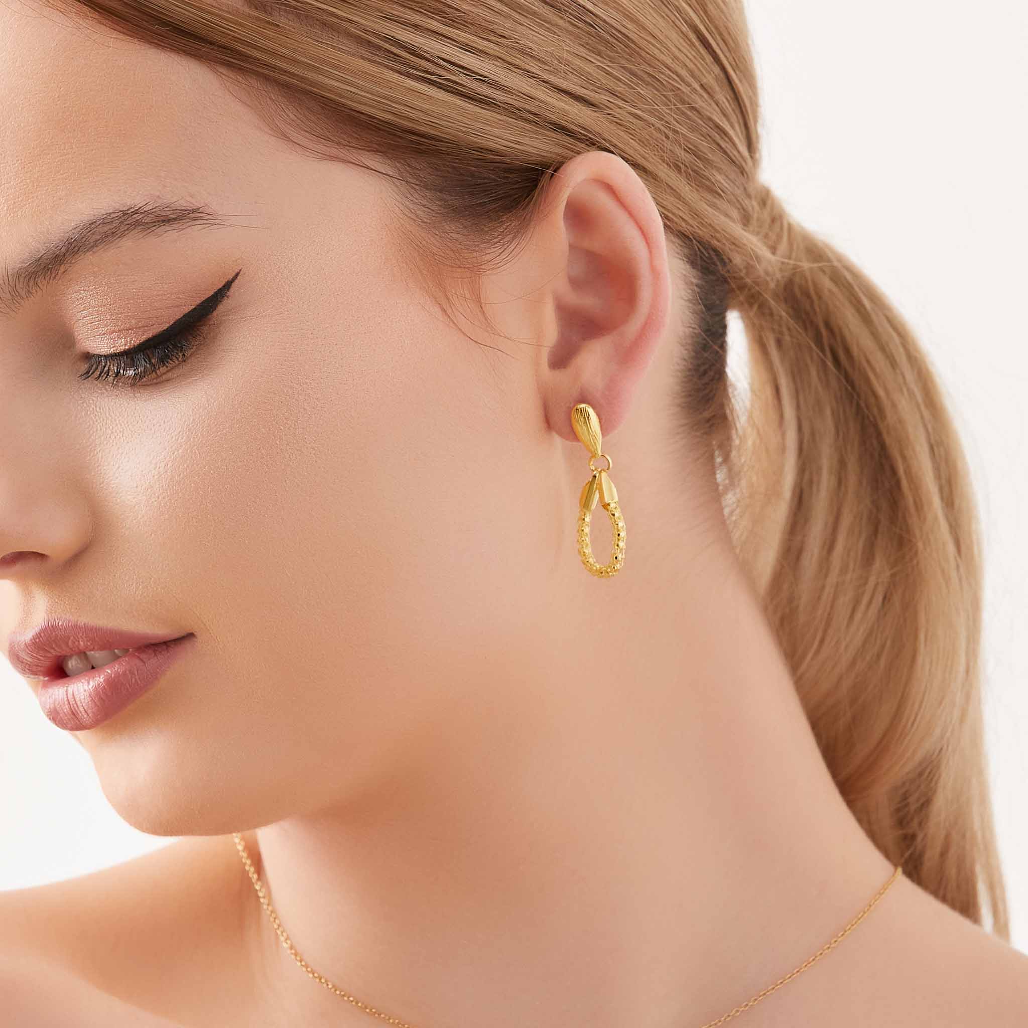 Gold teardrop loop earrings, side view