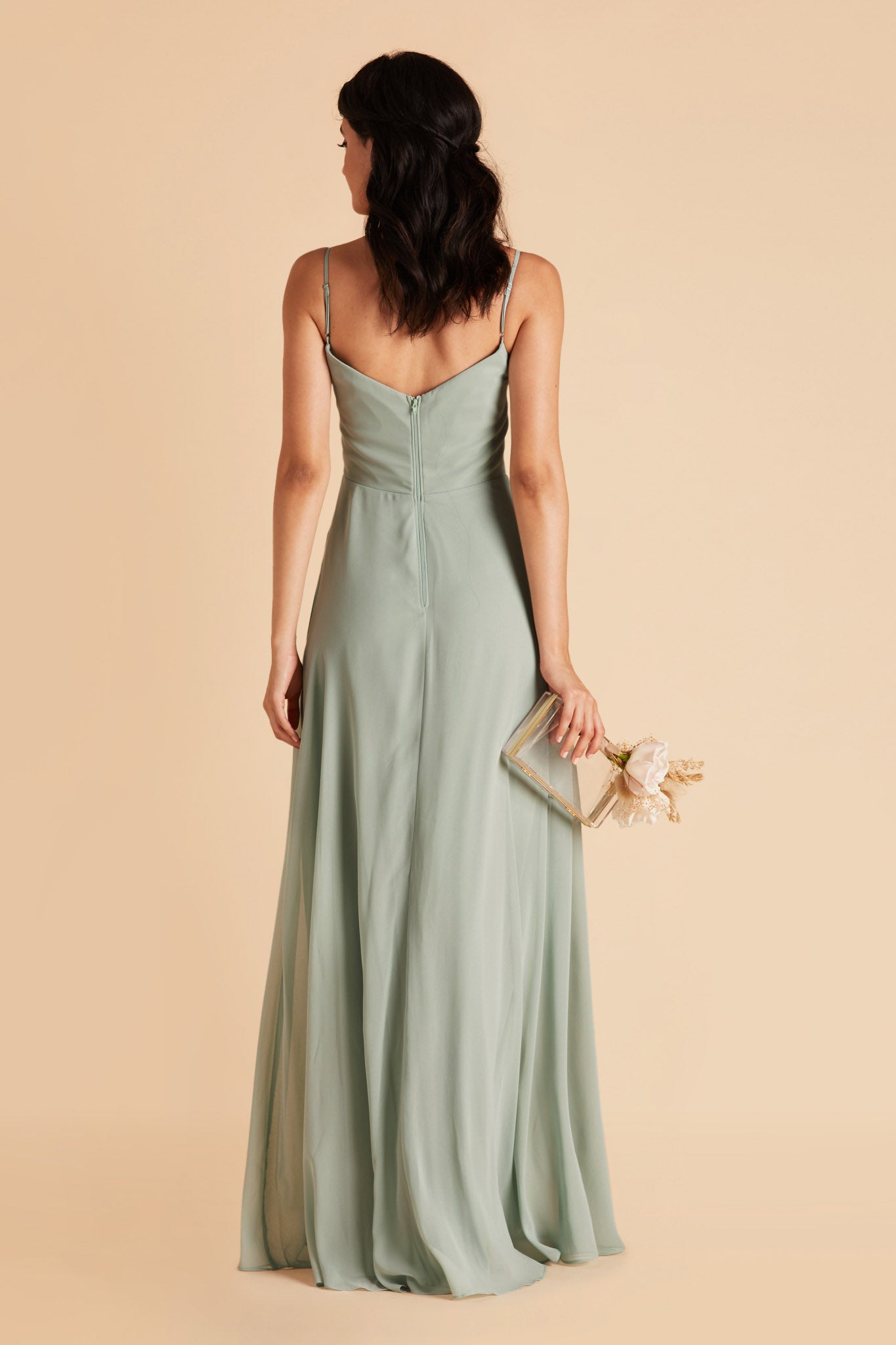 Back view of the floor-length Devin Convertible Bridesmaid Dress in sage chiffon displays adjustable spaghetti straps and an open back with a slight v-cut just below the shoulder blades.