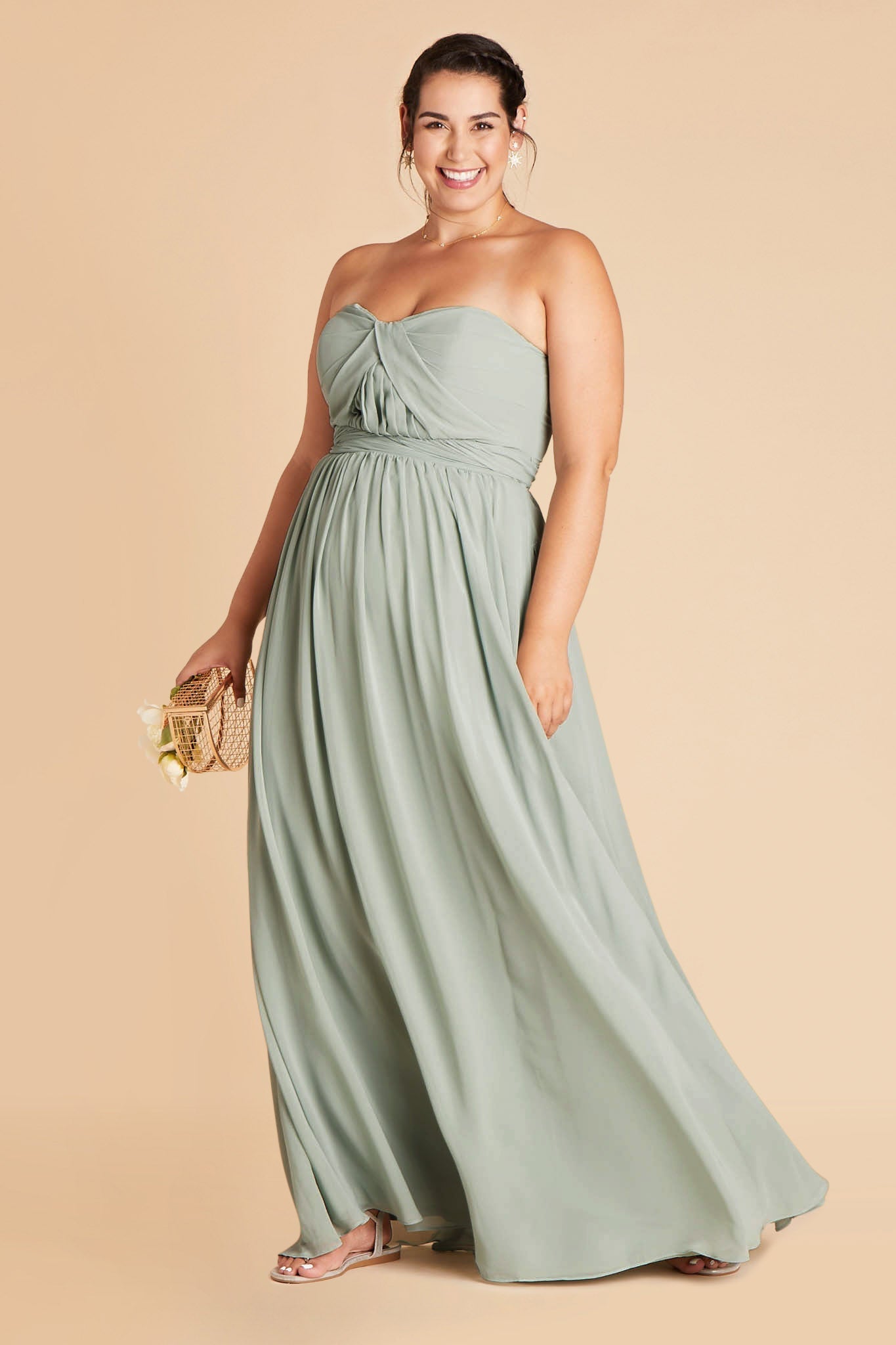 Front view of the floor-length Grace Convertible Plus Size Dress in sage chiffon features a fitted bust and waist with a flowing skirt that moves gracefully as the model steps forward.