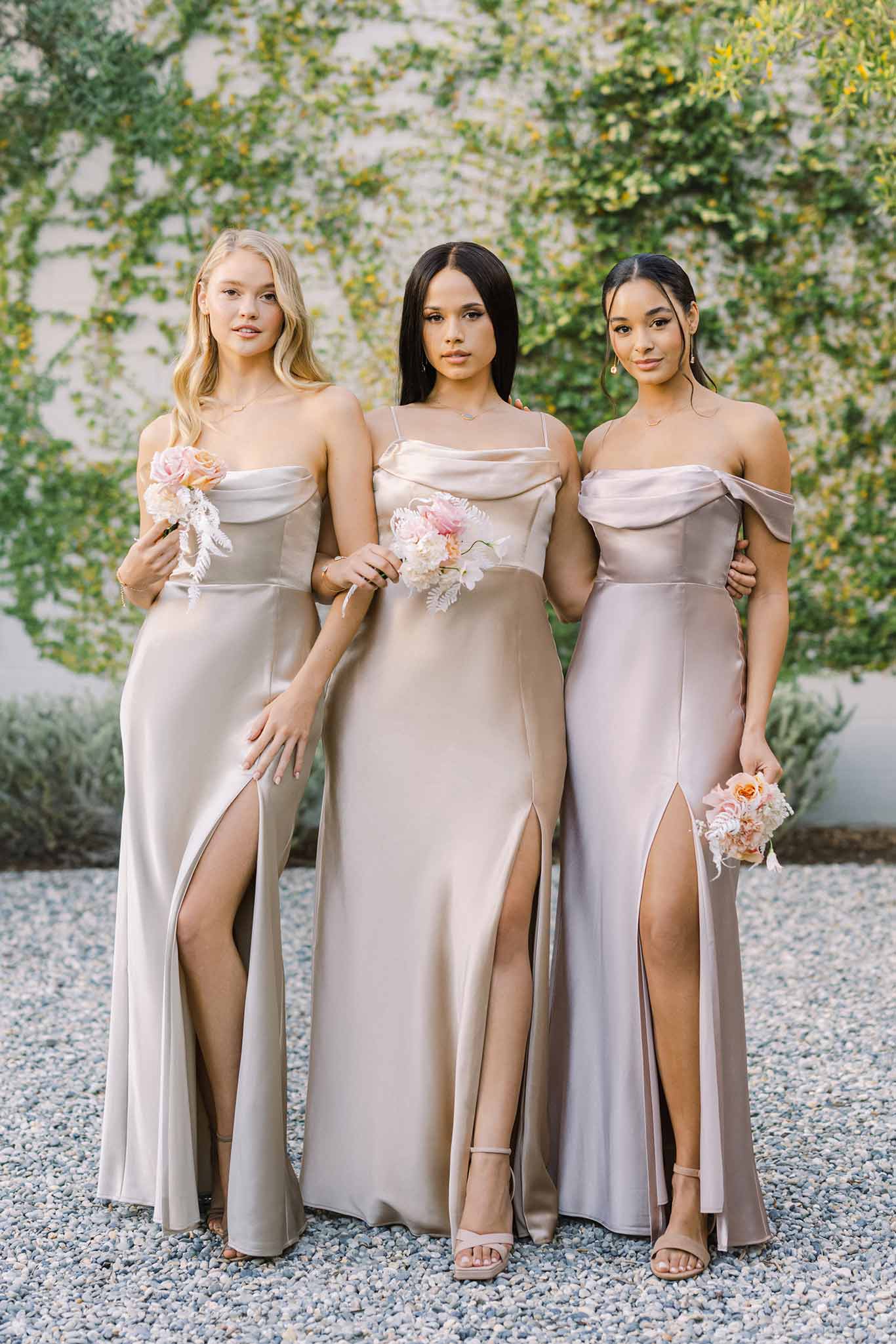 Three long satin bridesmaid dresses in champagne, taupe and gold satin with pleated cowl neck